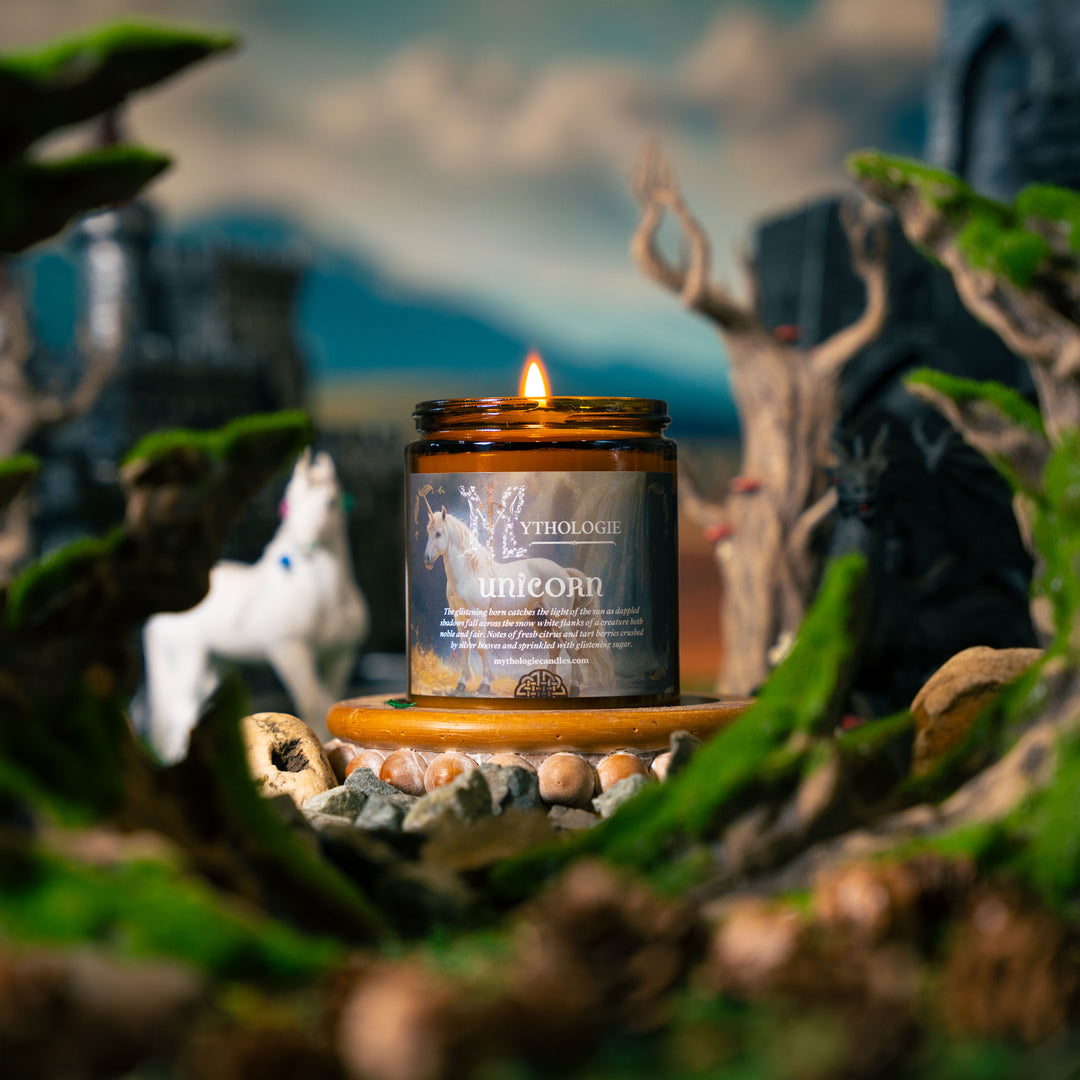 Candle in a decorative setting with nature elements and a blurred background